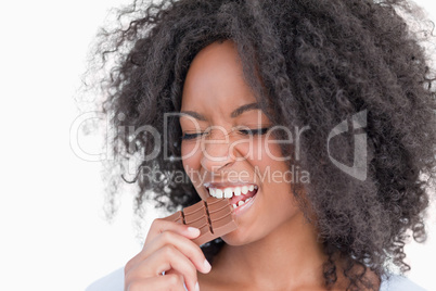Young woman closing her eyes while eating chocolate