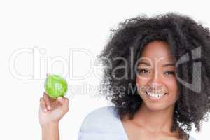 Smiling woman holding a green apple between her fingers