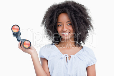 Young woman with curly hairstyle holding binoculars