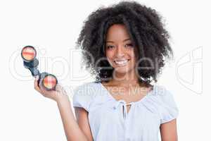 Young woman with curly hairstyle holding binoculars