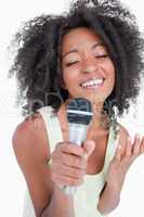Concentrated young woman singing into a microphone