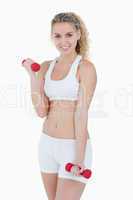 Smiling teenager in sportswear lifting weights