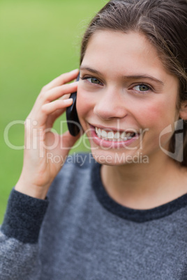Teenage girl calling with her mobile phone while looking at the