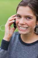 Teenage girl calling with her mobile phone while looking at the