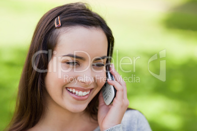 Smiling young woman using her mobile phone in the countryside