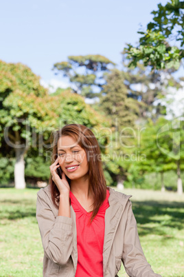 Woman smiling while making a phone call in and area surrounded b