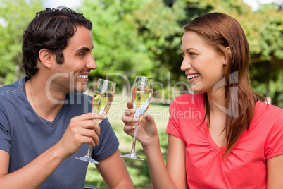 Two friends looking at each other while they are holding glasses