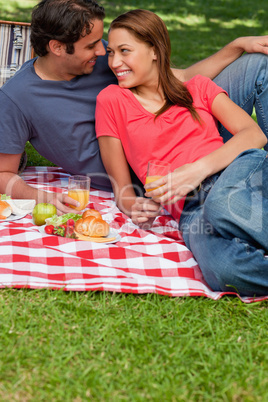 Two friends holding glasses while looking at each other as they