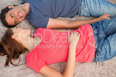 Two friends looking at each other while lying on a quilt