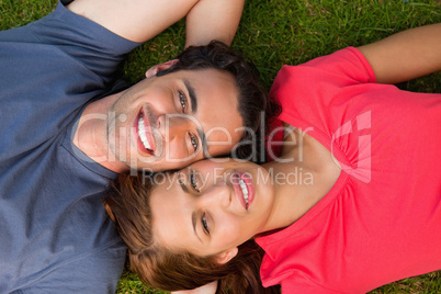 Two friends looking upwards while lying head to shoulder