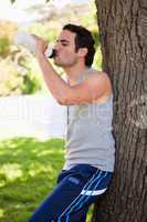 Man drinking from a sports bottle while resting