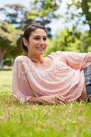 Smiling woman looking to her left while lying on her side