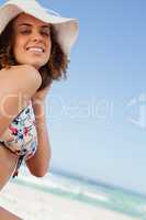 Smiling young woman proudly standing in front of the ocean