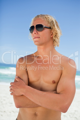 Blonde man looking towards the side while crossing his arms on t