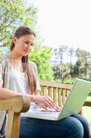 Woman on a park bench with her laptop