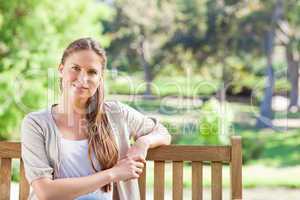 Relaxed woman sitting on a park bench