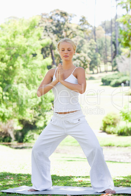 Relaxed woman doing yoga exercises in the park