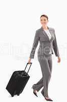 Smiling businesswoman walking with a suitcase