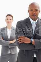 Businesswoman stands behind businessman