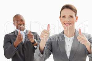 Smiling business people with thumbs up