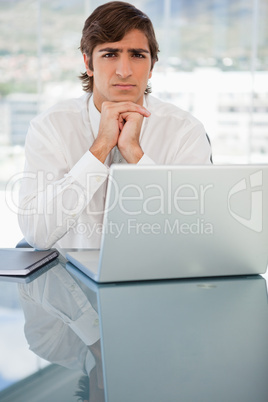 Serious young businessman with a laptop