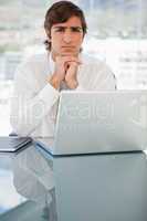 Serious young businessman with a laptop