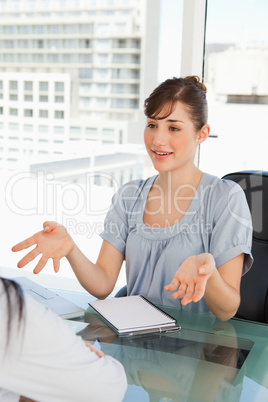 Smiling business woman talks to her fellow co-worker