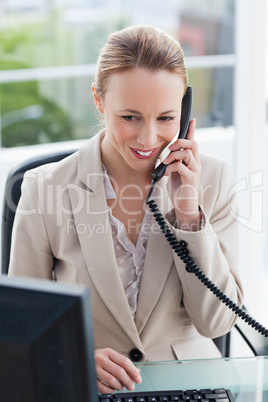 Woman in a suit on the phone in her office