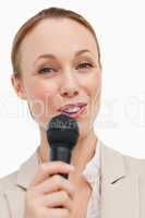 Portrait of a woman in a suit speaking with a microphone