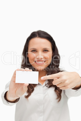 Brunette showing and pointing a card