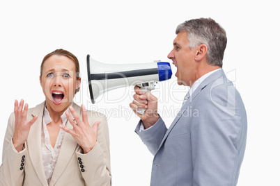 Businessman screaming after his colleague with a megaphone