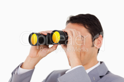 Man in a suit using binoculars