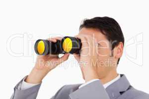 Man in a suit using binoculars