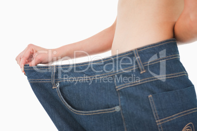 Close-up of a woman belly in a too big pants
