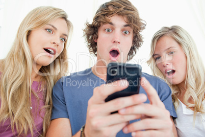 Three friends are surprised at the message on the phone