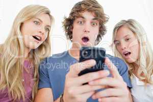 Three friends are surprised at the message on the phone
