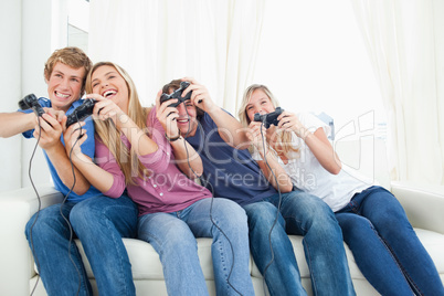 Friends enjoying video games as they all lean to the side