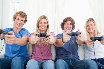 A smiling gang of friends as they look at the camera while gamin