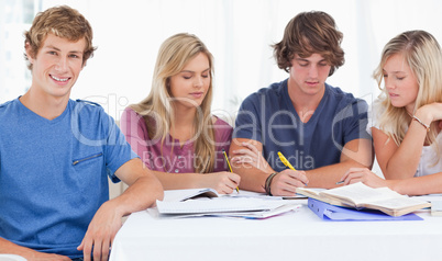 Four friends sitting at the table and studying