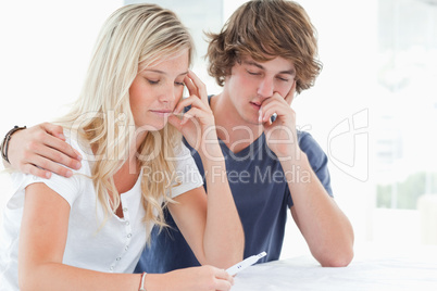 A worried couple holding a pregnancy test