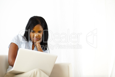 Calm young woman working on laptop at home