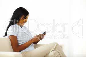 Cute young woman sending a text message