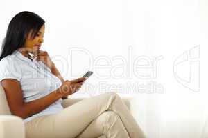 Cute young woman reading a text message