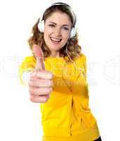 Thumbs-up woman enjoying music