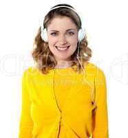 Smiling young woman listening music in headphones