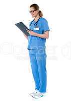 Female surgeon with stethoscope, reading report