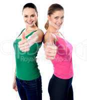 Smiling pretty girls gesturing thumbs-up