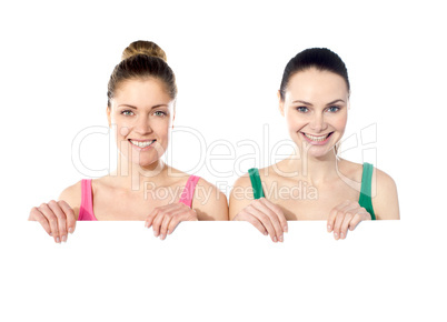 Teen girls holding white board