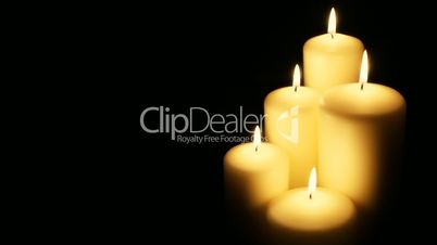 Five flickering candles on the black background