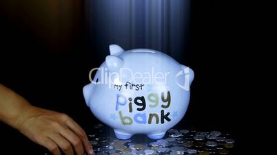 Piggy bank coin drop in black space,Piggy Bank Savings RMB and rays lights.